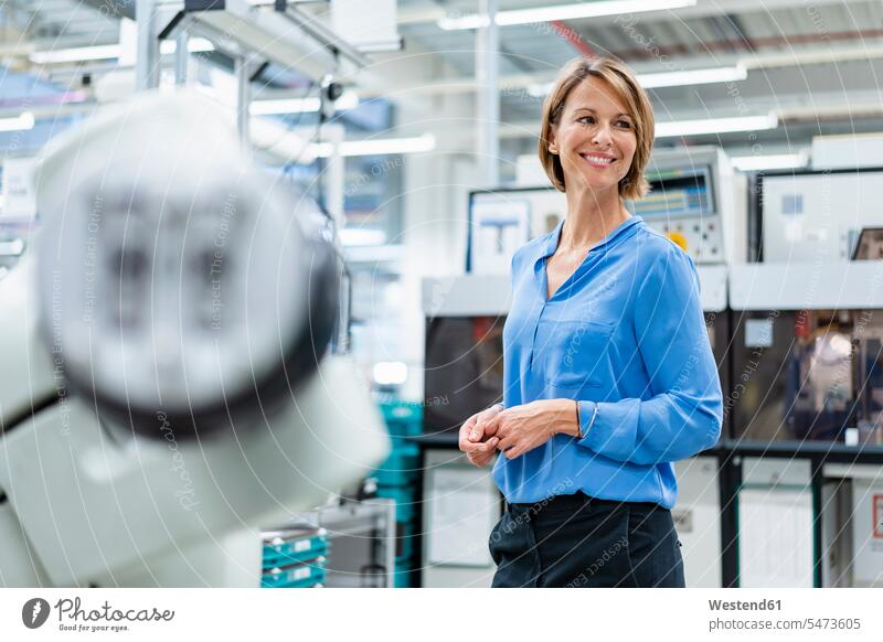 Porträt einer Geschäftsfrau am Montageroboter in einer Fabrik Job Berufe Berufstätigkeit Beschäftigung Jobs geschäftlich Geschäftsleben Geschäftswelt