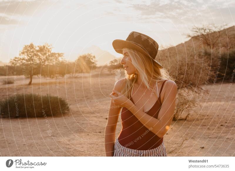 Namibia, Spitzkoppe, Frau mit Hut bei Sonnenuntergang Hüte Sonnenuntergänge weiblich Frauen Stimmung stimmungsvoll Atmosphäre Erwachsener erwachsen Mensch