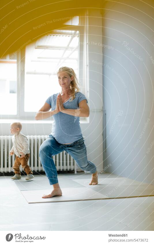 Schwangere Frau mit Kleinkind Sohn übt Yoga Yoga-Übungen Yogauebungen Yogaübungen Jogauebung Jogauebungen schwanger schwangere Frau üben ausüben trainieren