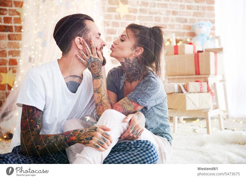 Glückliches junges Paar zu Hause zur Weihnachtszeit Zuhause daheim Weihnachten Christmas X-Mas X mas Pärchen Paare Partnerschaft glücklich glücklich sein