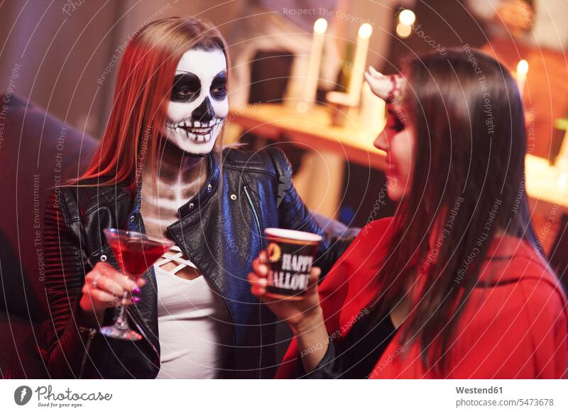 Frauen in gruseligem Kostüm trinken auf Party Freunde sprechen reden maskiert Parties Partys Halloween Abend vor Allerheiligen feiern Freundschaft Kameradschaft