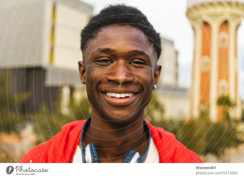Junger schwarzer Mann mit Kopfhörer, lächelnd, Porträt Schwarzer Afrikanisch Farbige Afrikanische Abstammung dunkelhäutig Farbiger Kopfhoerer rot rote roter