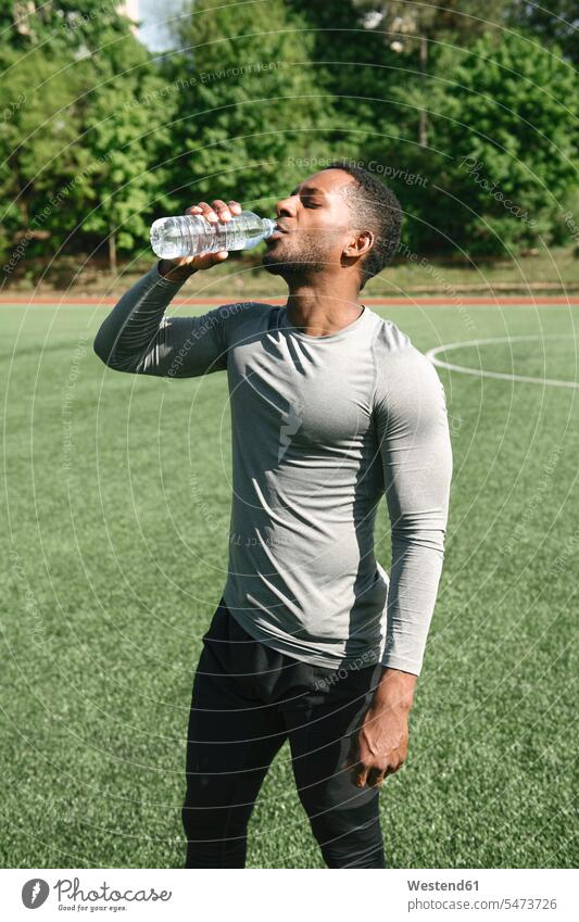 Sportler-Trinkwasser Bälle Fussball Fußbälle durstig graue grauer graues stehend steht Muße Anreiz Ansporn Antrieb motivieren motiviert trainieren