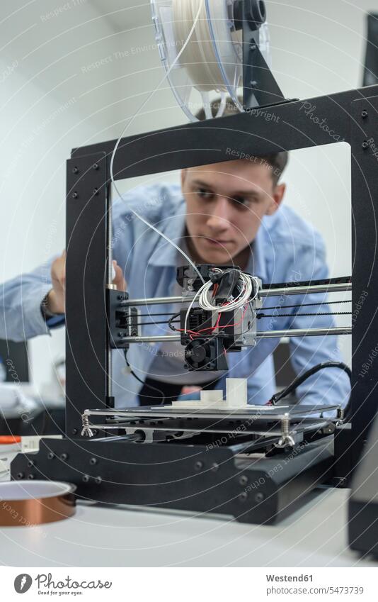 Schüler richten einen 3D-Drucker mit einem Laptop ein Job Berufe Berufstätigkeit Beschäftigung Jobs sitzend sitzt konzentrieren konzentriert drinnen