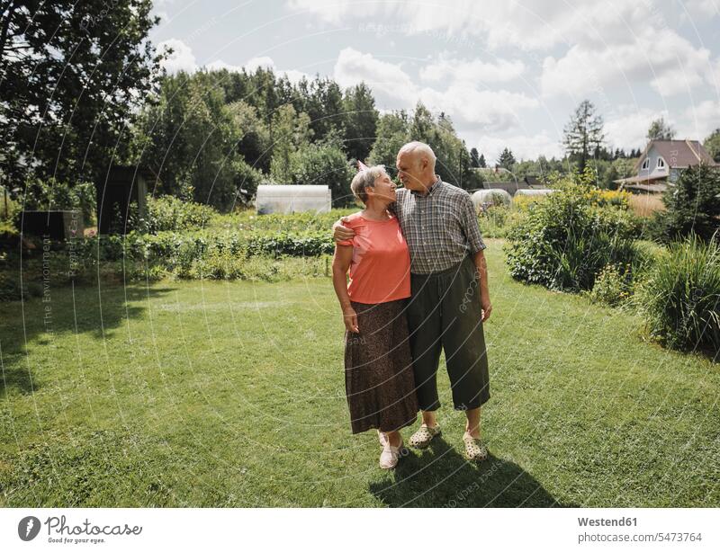 Glückliches Seniorenpaar im Garten stehend steht älteres Paar Seniorenpaare ältere Paare Seniorenpärchen glücklich glücklich sein glücklichsein Portrait