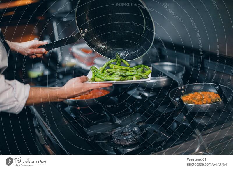 Chefkoch bereitet grünes Spargelgericht in der Restaurantküche Job Berufe Berufstätigkeit Beschäftigung Jobs Gastronomie Koeche Kuechenchef Kuechenchefs Köche