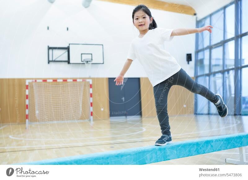 Schulmädchen balanciert auf Balancierbalken im Sportunterricht Schwebebalken Schule Schulen Schülerin Schuelerin Schülerinnen Schuelerinnen balancieren Balance