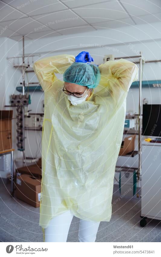 Arzt nimmt im Krankenhaus persönliche Schutzausrüstung ab Job Berufe Berufstätigkeit Beschäftigung Jobs Gesundheit Gesundheitswesen medizinisch Krankenpflegerin