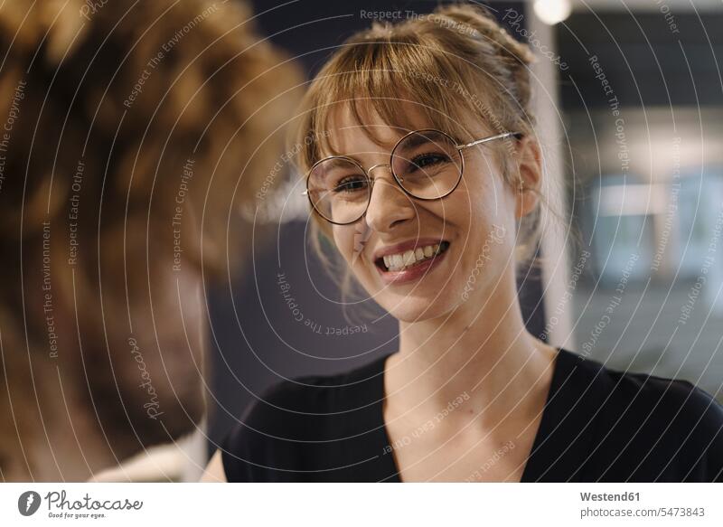 Porträt einer lächelnden Geschäftsfrau, die einen Geschäftsmann im Büro ansieht Arbeitskollege Arbeitskollegen Kollege Job Berufe Berufstätigkeit Beschäftigung
