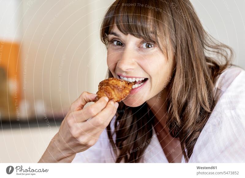 Porträt einer glücklichen Frau, die ein Croissant isst Leute Menschen People Person Personen Europäisch Kaukasier kaukasisch 1 Ein ein Mensch nur eine Person