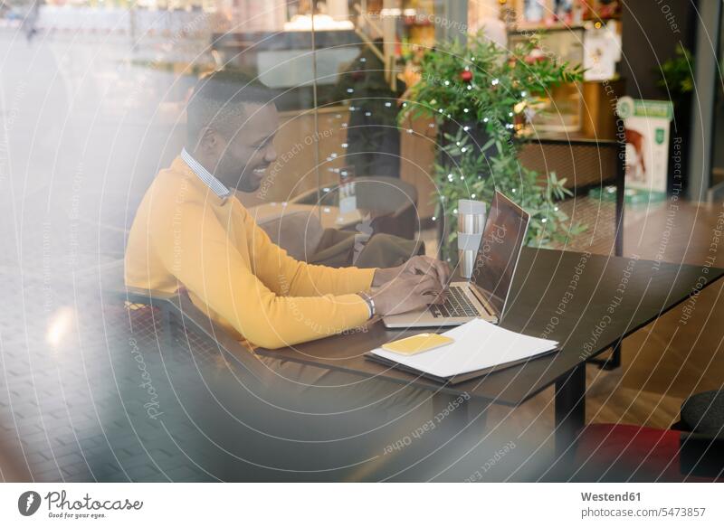 Glücklicher Mann mit Laptop in einem Café Job Berufe Berufstätigkeit Beschäftigung Jobs geschäftlich Geschäftsleben Geschäftswelt Geschäftsperson