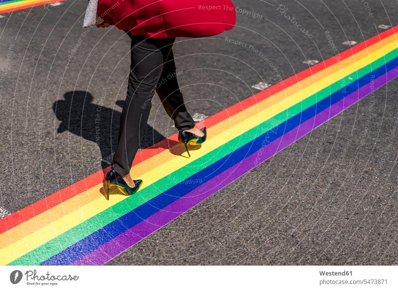 Beine einer Geschäftsfrau, die auf LGBT-Streifen die Straße überquert, London, UK geschäftlich Geschäftsleben Geschäftswelt Geschäftsperson Geschäftspersonen