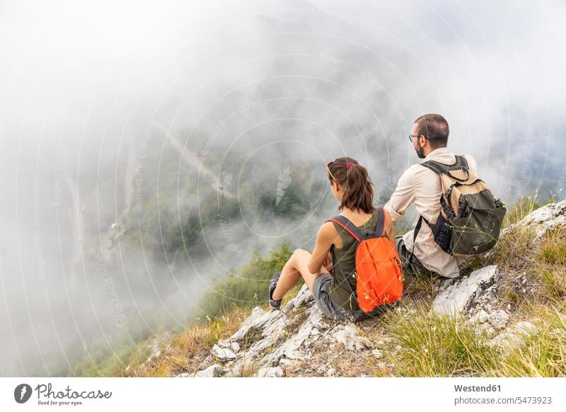 Italien, Massa, Paar mit Blick auf die schöne Aussicht in den Alpi Apuane wandern Wanderung schauen sehend sitzen sitzend sitzt Berg Berge Ausblick Ansicht