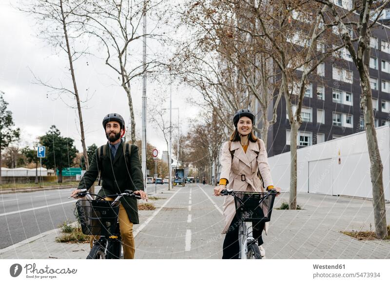 Pärchen fährt mit E-Bikes in der Stadt radfahren fahrradfahren radeln eBikes Elektrofahrrad Elektrorad staedtisch städtisch Radweg Fahrradweg Paar Paare