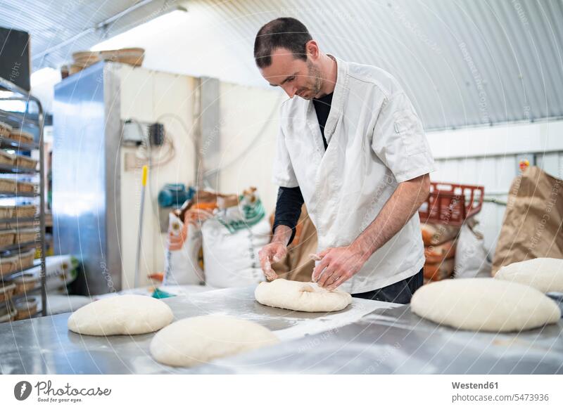 Bäcker bereitet Brotlaibe in Bäckerei vor Leute Menschen People Person Personen Europäisch Kaukasier kaukasisch Südeuropäisch 1 Ein ein Mensch eine