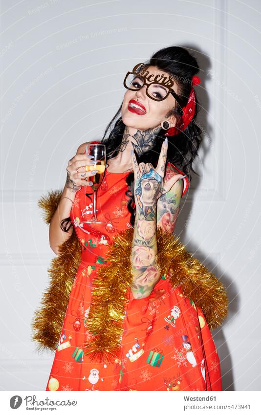 Porträt einer tätowierten Frau mit Champagnerglas und Rock-and-Roll-Zeichen weiblich Frauen Rock And Roll rock 'n' roll Tattoo Tätowierungen Tatoos Taetowierung