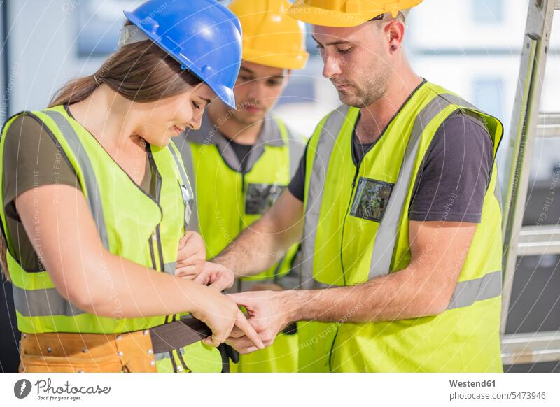 Bauarbeiter hilft Kollege mit Werkzeuggürtel Baustelle Baustellen Kollegen Arbeitskollegen helfen mithelfen Hilfsbereitschaft beistehen Mithilfe Beistand Hilfe