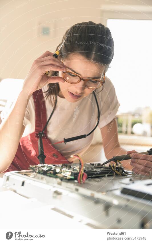 Junge Frau bei der Arbeit am Computer zu Hause Deutschland Schaltplatte Leiterplatine Printplatte Kompetenz Fähigkeit Können Wohnen Aufmerksamkeit aufmerksam