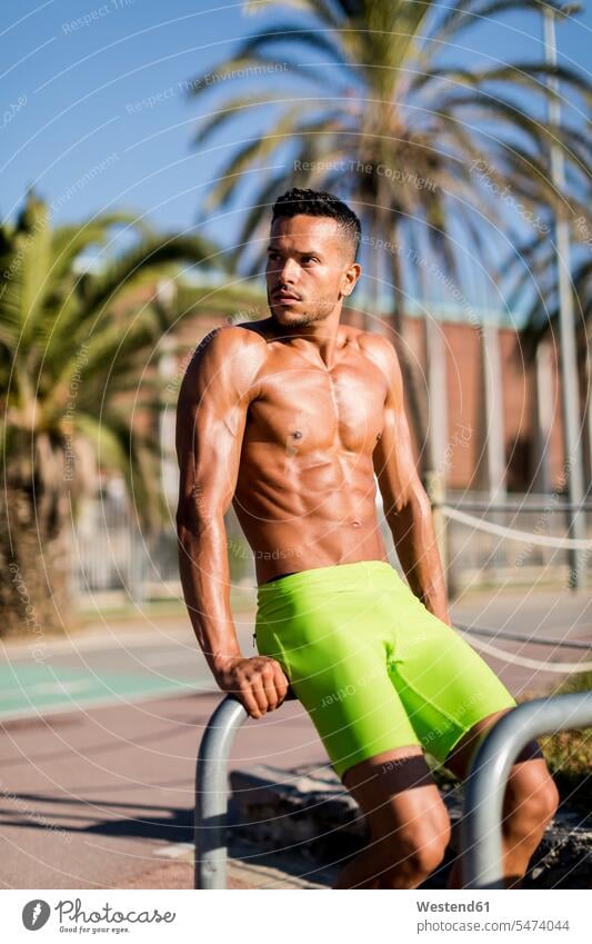 Nackter muskulöser Mann trainiert im Freien und schaut sich um Muskeln athletisch Workout trainieren umherblicken umschauen umsehen Männer männlich Mensch