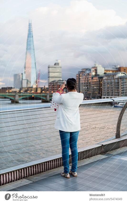 UK, London, Frau, die auf einer Brücke steht und The Shard fotografiert stehen stehend weiblich Frauen Bruecken Brücken fotografieren Erwachsener erwachsen