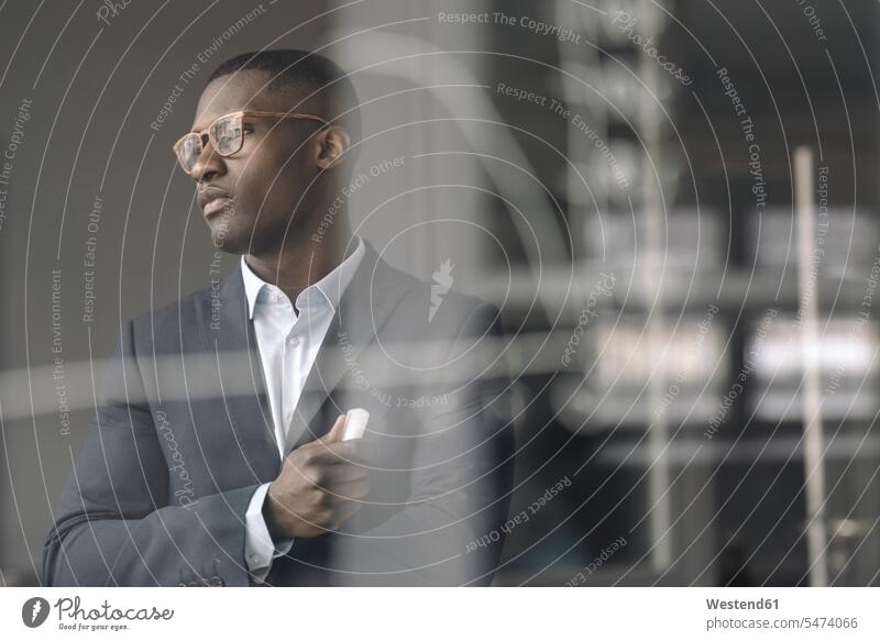 Porträt eines jungen Geschäftsmannes hinter Diagramm auf Glasscheibe im Büro Job Berufe Berufstätigkeit Beschäftigung Jobs geschäftlich Geschäftsleben