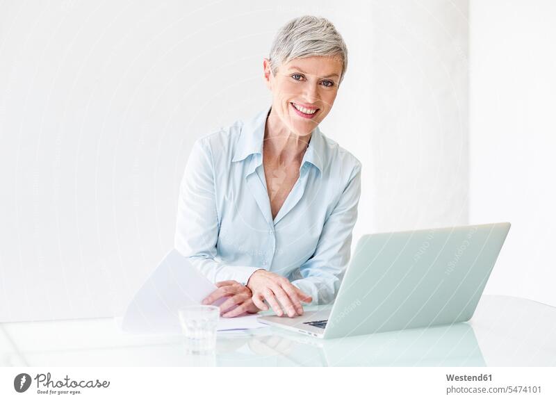 Porträt einer lächelnden reifen Geschäftsfrau, die an einem Laptop arbeitet Karrierefrau Karrierefrauen arbeiten Arbeit Notebook Laptops Notebooks Portrait