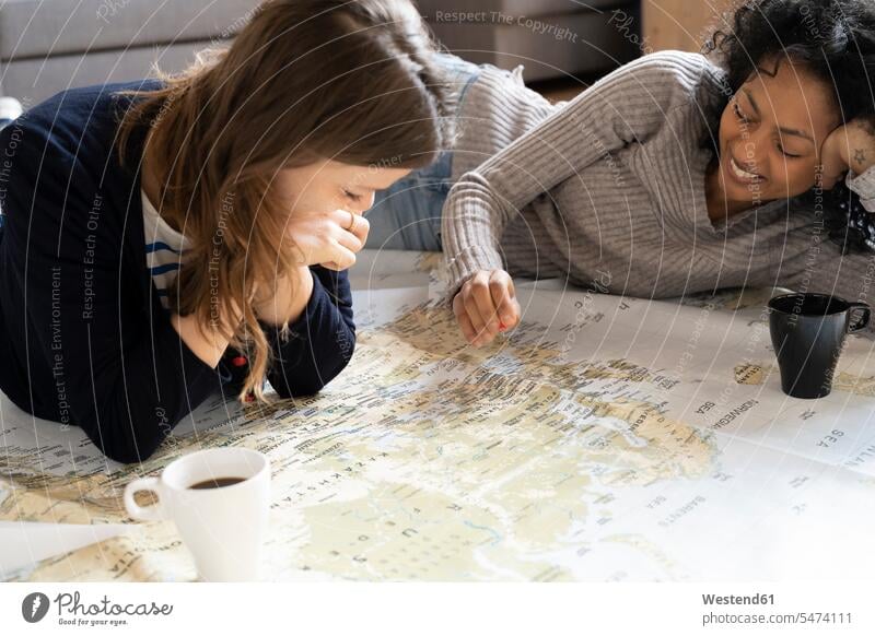 Freunde setzen Stecknadeln auf eine Karte, planen ihren Urlaub Landkarte Landkarten Freundinnen Ferien Reiseziel Reiseziele Urlaubsziel liegen liegend liegt
