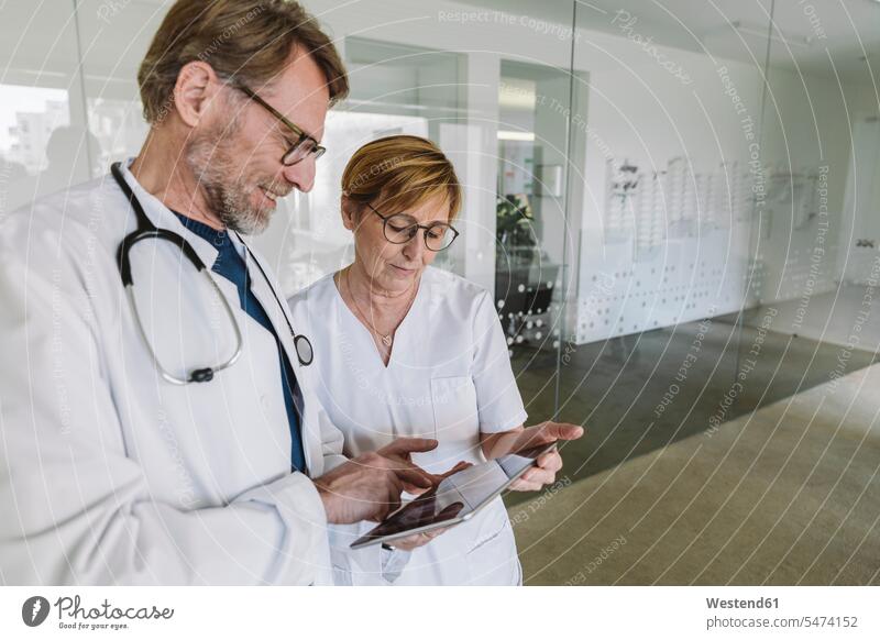 Arzt und Assistentin verwenden Tabletten in der medizinischen Praxis Job Berufe Berufstätigkeit Beschäftigung Jobs Gesundheit Gesundheitswesen Krankenpflegerin