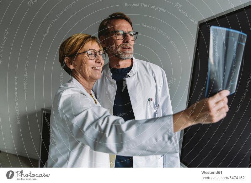 Zwei Ärzte diskutieren über Röntgenbild Job Berufe Berufstätigkeit Beschäftigung Jobs Bilder Bildnis Roentgenbild Roentgenbilder Röntgenbilder Brillen reden