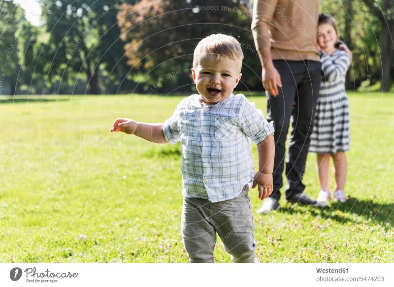 Glücklicher Junge mit Familie in einem Park Parkanlagen Parks glücklich glücklich sein glücklichsein männliche Babys männliches Baby männliche Babies Familien