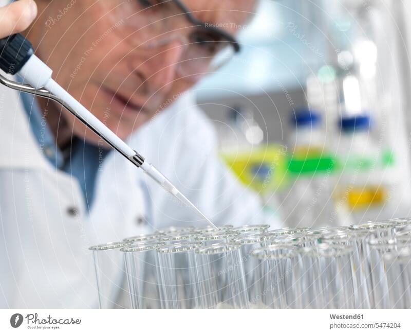 Wissenschaftler pipettieren während eines Experiments im Labor in Reagenzgläser Reagenzglas Labore experimentieren Laborgeräte Laborgeraet Laborbedarf