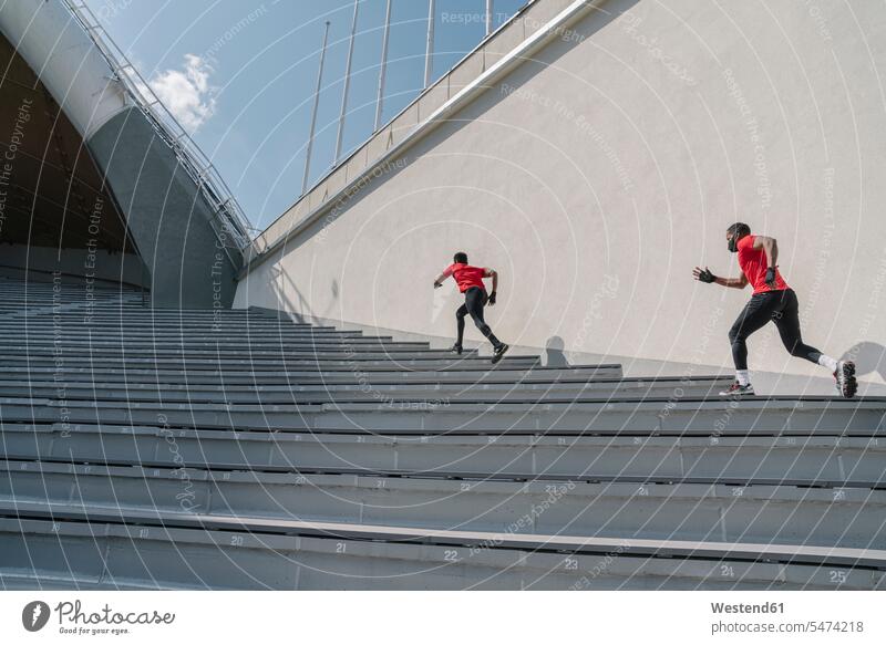 Sportler mit Gesichtsmasken beim Treppensteigen Freunde Kameradschaft rennen Farben Farbtoene Farbton Farbtöne rote roter rotes Leistungen Dynamik dynamisch
