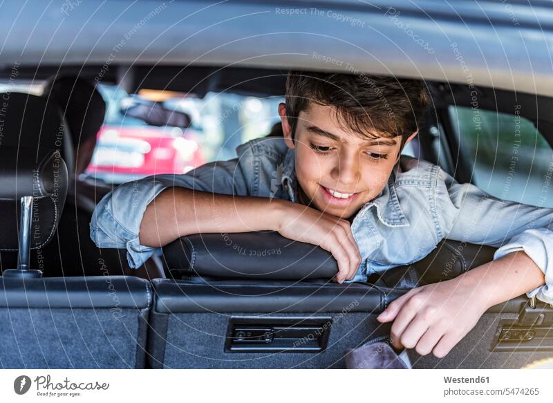 Lächelnder Junge im Auto, der in den Kofferraum schaut lächeln Buben Knabe Jungen Knaben männlich Gepäckraum Kofferräume Wagen PKWs Automobil Autos ansehen Kind