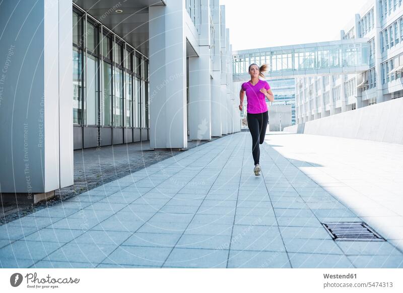 Junge Frau läuft in der Stadt staedtisch städtisch weiblich Frauen laufen rennen Außenaufnahme draußen im Freien Erwachsener erwachsen Mensch Menschen Leute