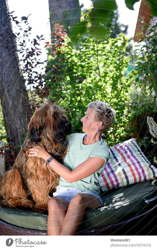 Lächelnde Frau mit ihrem Hund im Garten Hunde Gärten Gaerten lächeln weiblich Frauen Haustier Haustiere Tier Tierwelt Tiere Erwachsener erwachsen Mensch