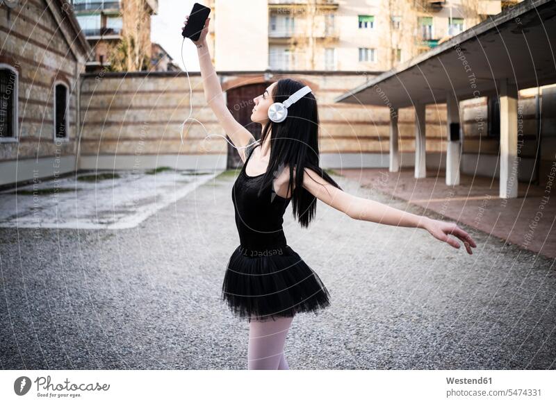 Italien, Verona, Frau im Ballettkleid mit Handy und Kopfhörer Kopfhoerer Mobiltelefon Handies Handys Mobiltelefone weiblich Frauen Stadt staedtisch städtisch