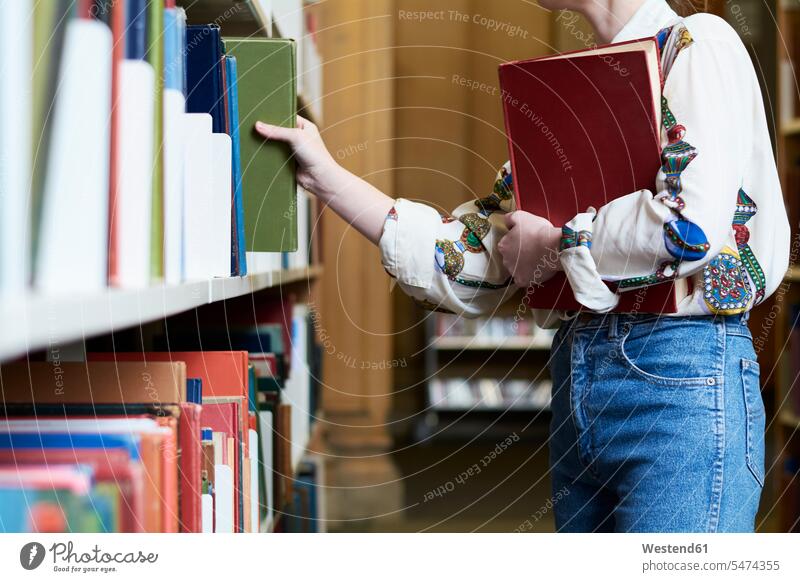 Studentin mit einem Buch in einer öffentlichen Bibliothek, die sich eines aussucht nehmen Frau lesen Erwachsener Mensch Akademische Bildung Intelligenz Neugier