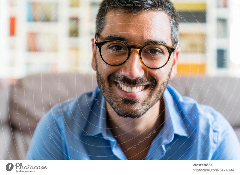 Porträt eines glücklichen jungen Mannes, der zu Hause eine Brille trägt Leute Menschen People Person Personen Europäisch Kaukasier kaukasisch 1 Ein ein Mensch