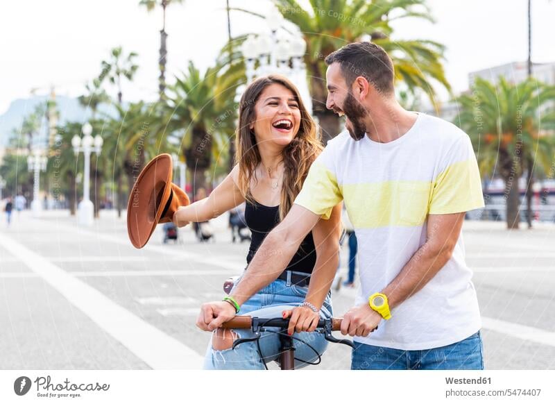 Spanien, Barcelona, ein Paar, das Spaß hat und gemeinsam eine Fahrradtour an der Strandpromenade macht Spass Späße spassig Spässe spaßig Promenade Promenaden