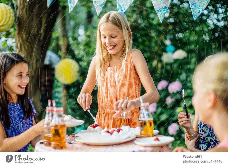 Mädchen, das auf einer Geburtstagsfeier im Freien Kuchen auftischt Freunde Kameradschaft Freundin Flaschen Deko Dekorationen dekorieren Tische Jahreszeiten