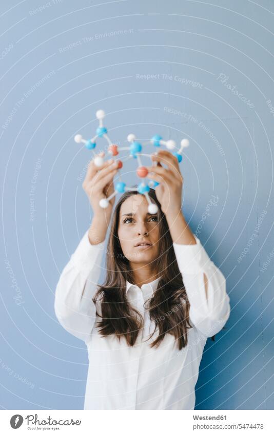 Weibliche Wissenschaftlerin mit Molekülmodell, die nach Lösungen sucht Frau halten Erwachsener Mensch gemischtrassige Person Einfallsreichtum Innovation smart