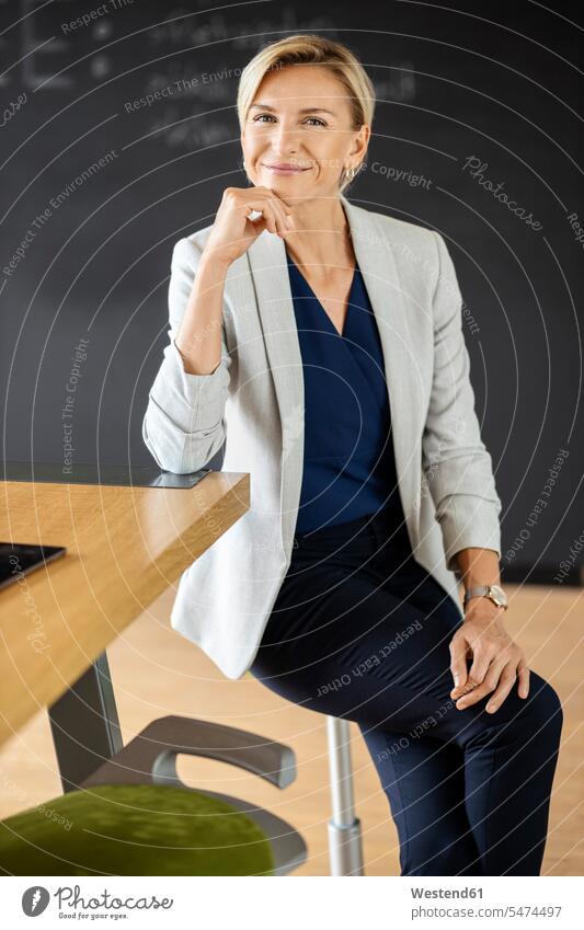 Porträt einer selbstbewussten blonden Geschäftsfrau im Konferenzraum mit Tafel Job Berufe Berufstätigkeit Beschäftigung Jobs geschäftlich Geschäftsleben