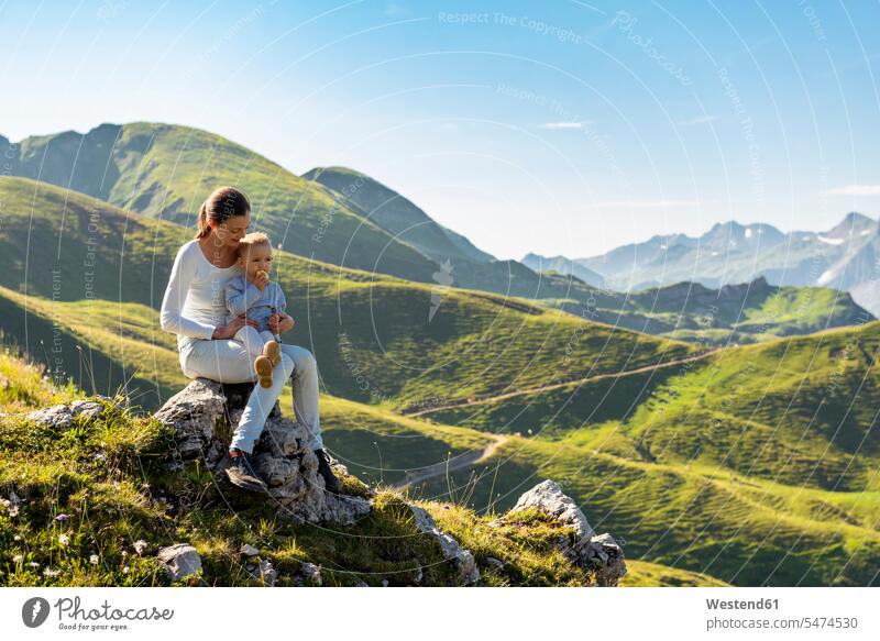 Deutschland, Bayern, Oberstdorf, Mutter und kleine Tochter auf einer Wanderung in den Bergen beim Pausieren Mamas Mami Mutti Mütter Muetter Mamis Muttis Pause
