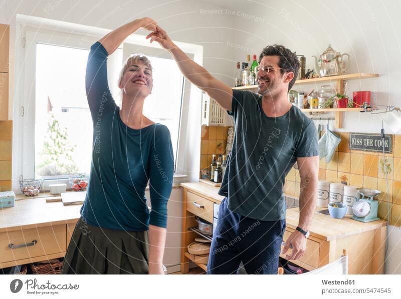 Glückliches Paar tanzt zu Hause in der Küche Leute Menschen People Person Personen erwachsen 30 - 40 Jahre 30 bis 40 30 bis 40 Jahre 30-40 35 - 40 Jahre