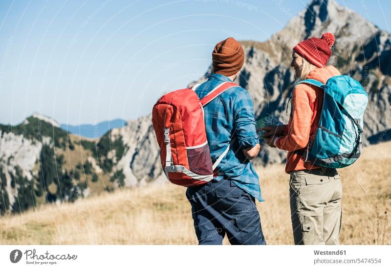 Österreich, Tirol, Paar mit Karte beim Wandern in den Bergen Karten Gebirge Berglandschaft Gebirgslandschaft Gebirgskette Gebirgszug wandern Wanderung Pärchen