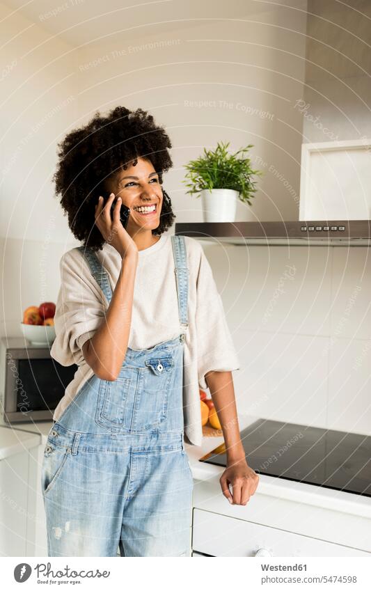Glückliche Frau am Handy in der Küche zu Hause Mobiltelefon Handies Handys Mobiltelefone weiblich Frauen Zuhause daheim glücklich glücklich sein glücklichsein
