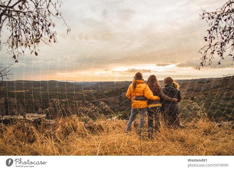 Spanien, Alquezar, drei Freunde umarmen sich auf einem Hügel mit Blick auf die Landschaft Frau weiblich Frauen überblicken hügelig Anhöhe Berg Umarmung