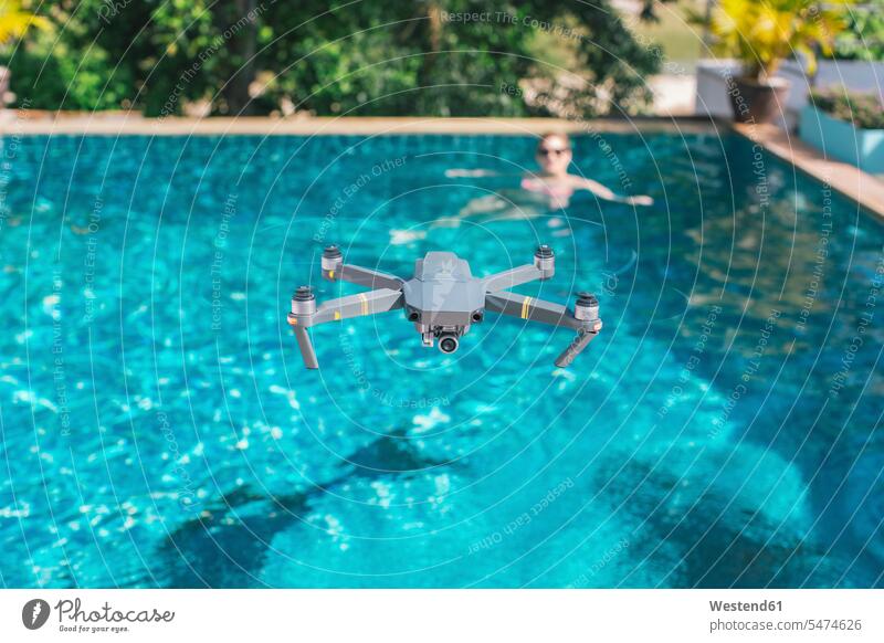 Fliegende Drohne über dem Schwimmbad Technik Techniken Technologie Textfreiraum in der Luft schweben schwebend Swimmingpool Swimmingpools Schwimmbecken