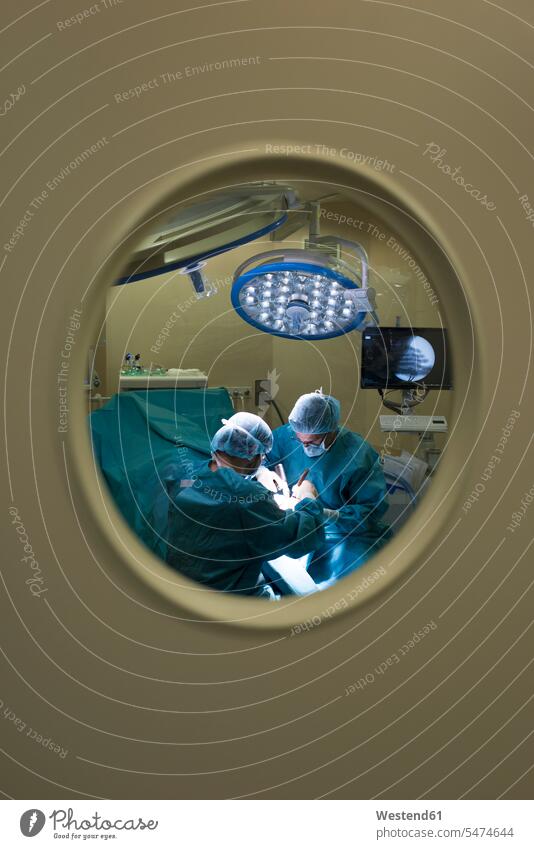 Chirurgen während einer Operation hinter der Tür Leute Menschen People Person Personen Europäisch Kaukasier kaukasisch 2 2 Menschen 2 Personen zwei