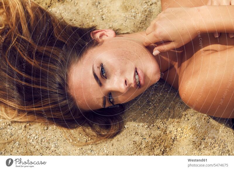 Porträt einer lasziven jungen Frau, die am Strand liegt Portrait Porträts Portraits weiblich Frauen liegen liegend Beach Straende Strände Beaches Erwachsener
